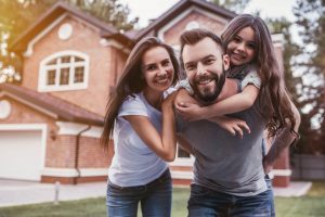 Smiling Family in Front of Home in Nassau County, NY