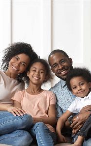 Smiling Family Sitting on Sofa